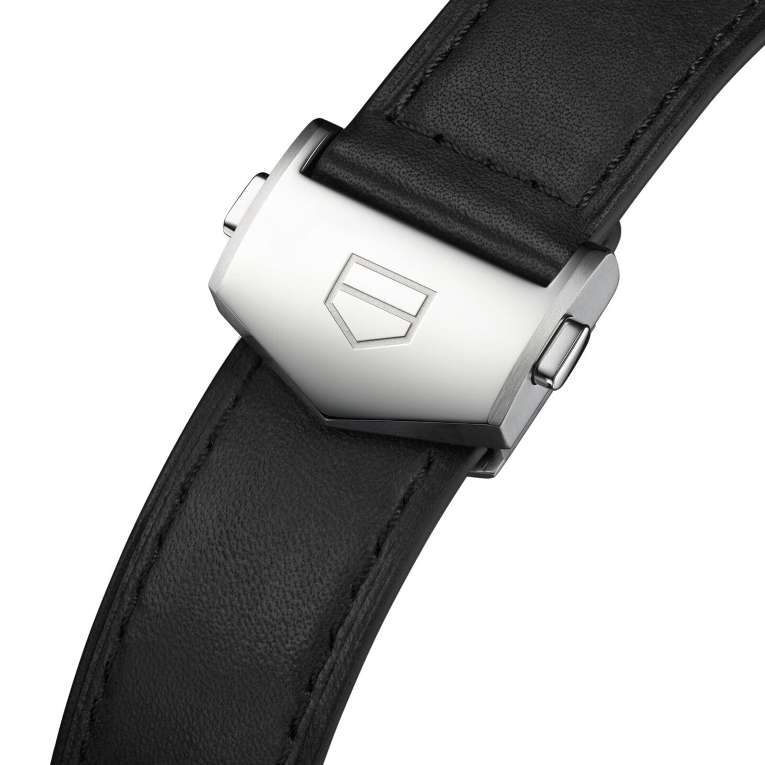 Close-up of the TAG Heuer Carrera Chronograph’s black leather strap with a silver clasp engraved with a geometric logo, showcasing its automatic movement.