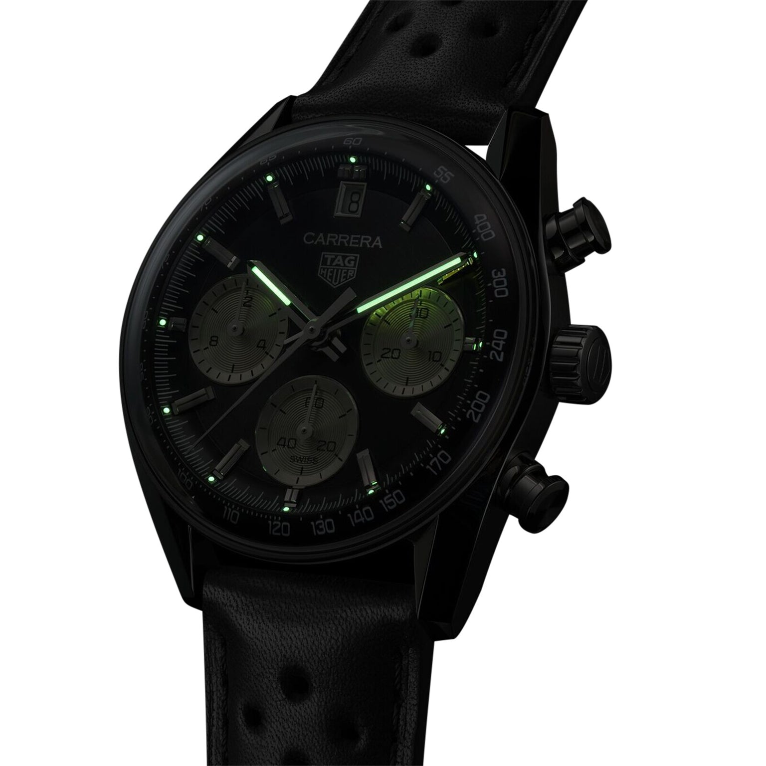 The TAG Heuer Carrera Chronograph is a black watch with a perforated leather strap and luminous green hands and hour markers, powered by an automatic movement.