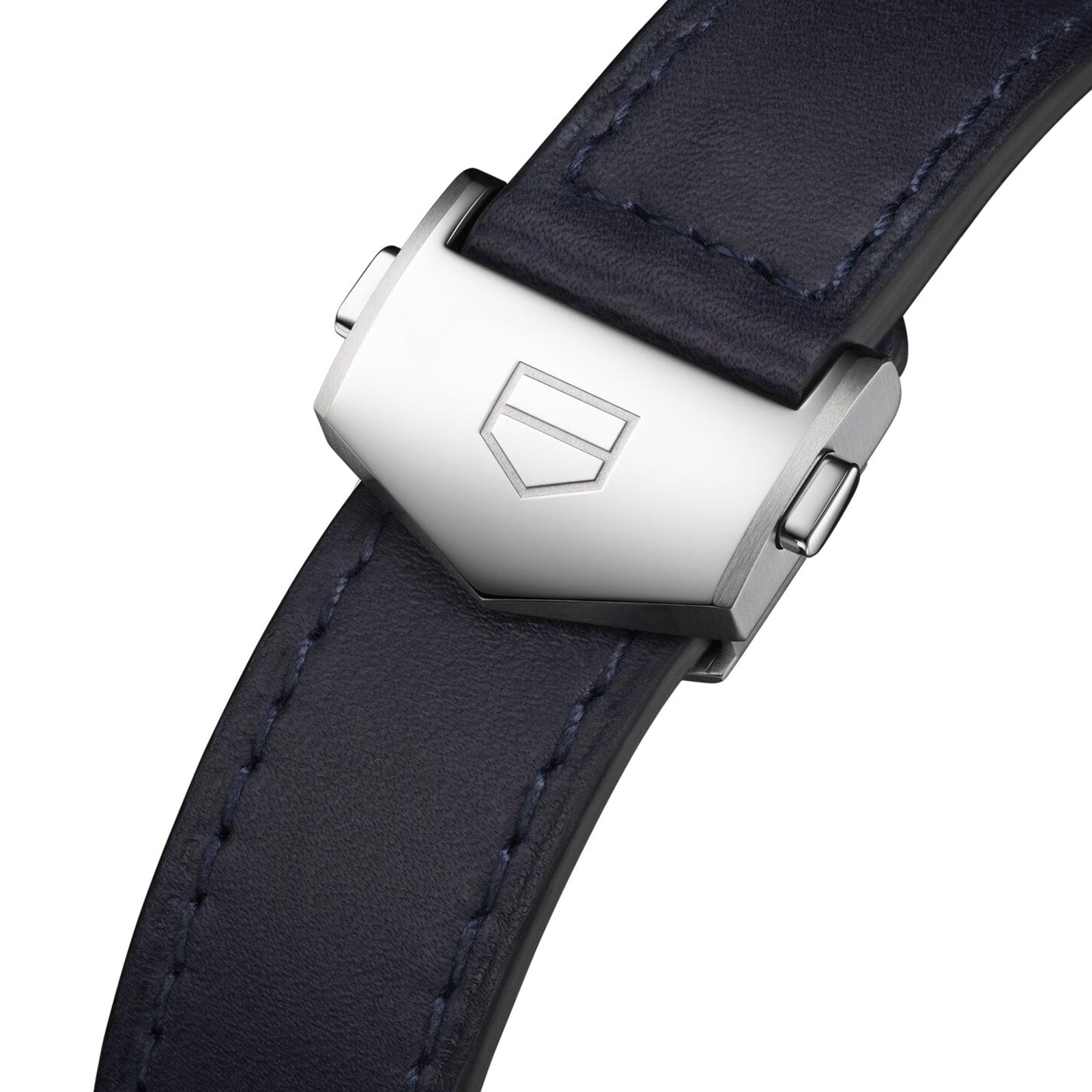 Close-up of a dark leather strap with a silver clasp engraved with TAG Heuer’s geometric shield logo, reflecting the refined style of the Carrera Chronograph, inspired by the legendary Carrera Panamericana race.