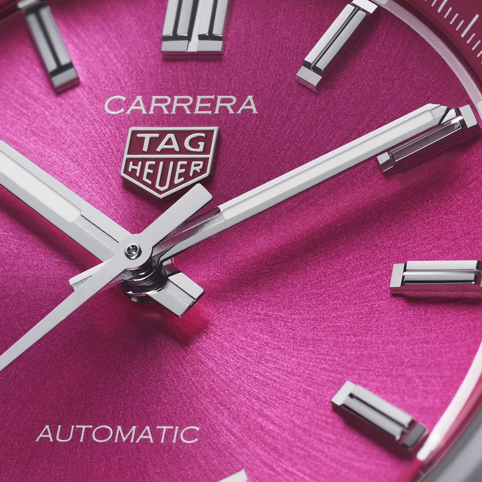 Close-up of the TAG Heuer Carrera Date watch, featuring a metallic pink dial, silver hour markers and hands, with the TAG Heuer logo and Automatic text—an enduring timepiece powered by automatic movement.