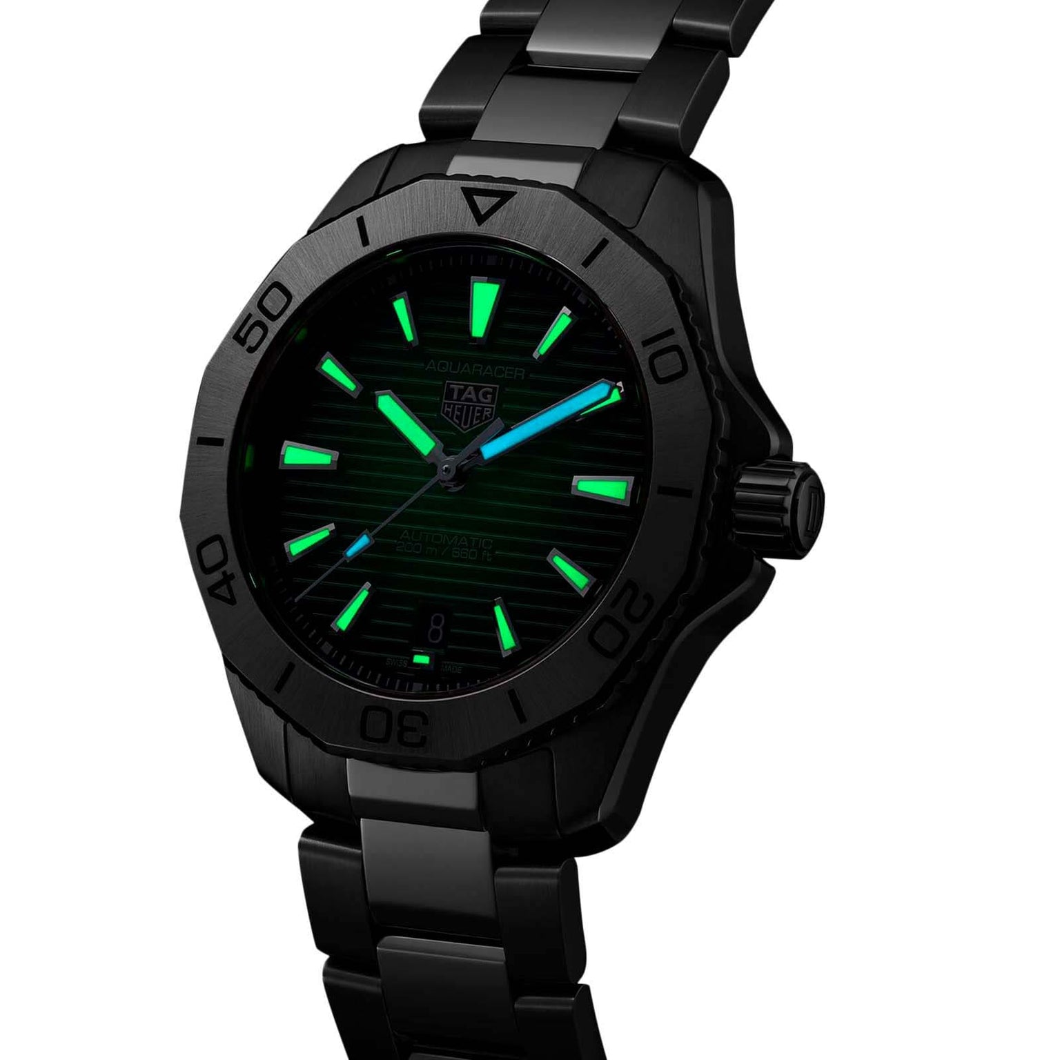 A TAG Heuer Aquaracer Professional 200 watch with a black dial, stainless steel case and band, and luminous green markers and hands is displayed at an angle.