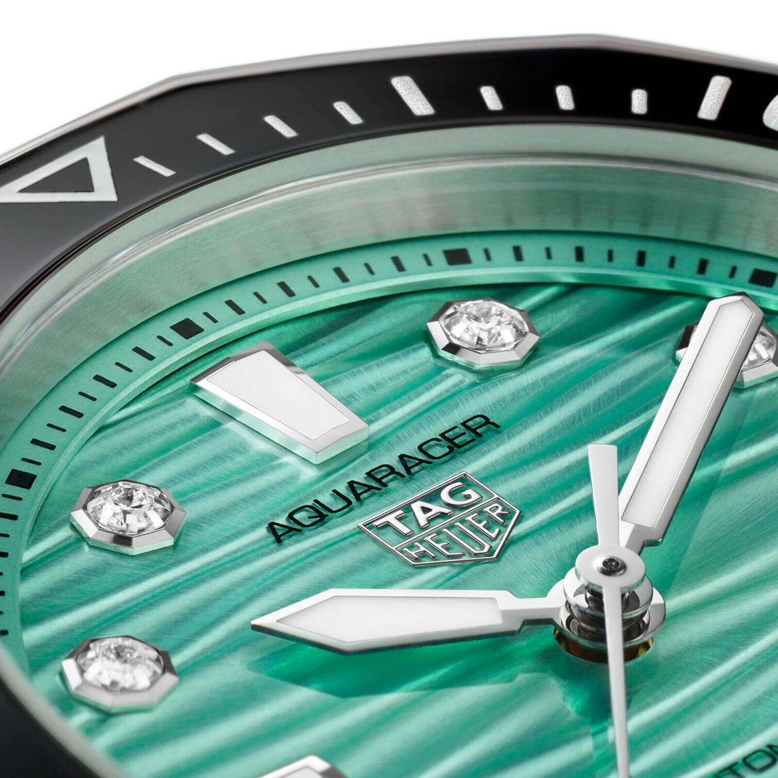 Close-up of a TAG Heuer Aquaracer Professional 300 Date watch face featuring a green textured dial, silver hands, and diamond hour markers.