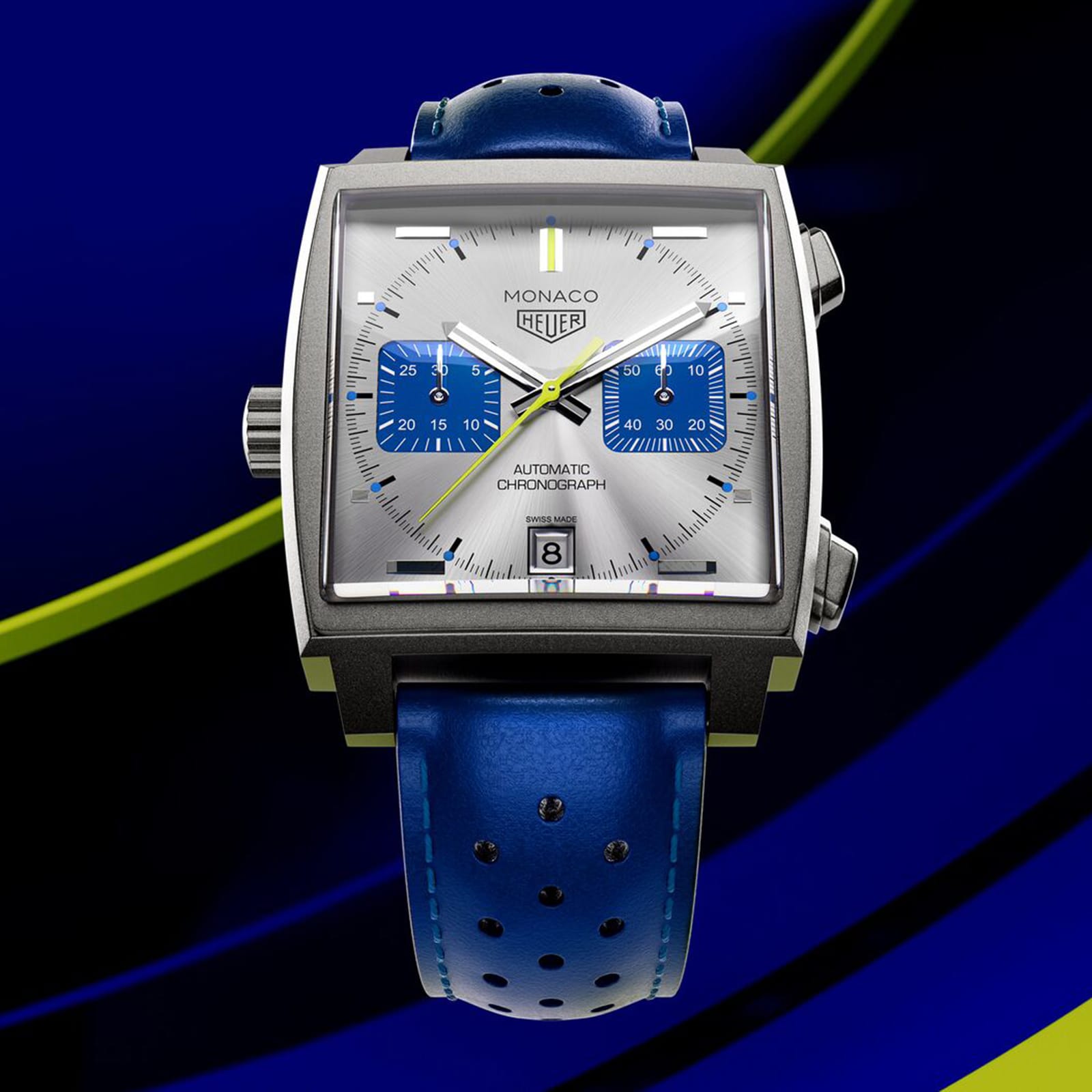 The TAG Heuer Limited Edition Monaco Chronograph French Racing Blue features a square case, silver dial with blue subdials, date display, blue perforated leather strap, and Calibre 11 movement, set against a blue and yellow abstract background.
