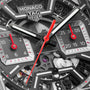 Close-up of the TAG Heuer Monaco Chronographs face, showcasing a skeletonised dial with black, gray, and red accents, exposed gears, and dual subdials for seconds and minutes.