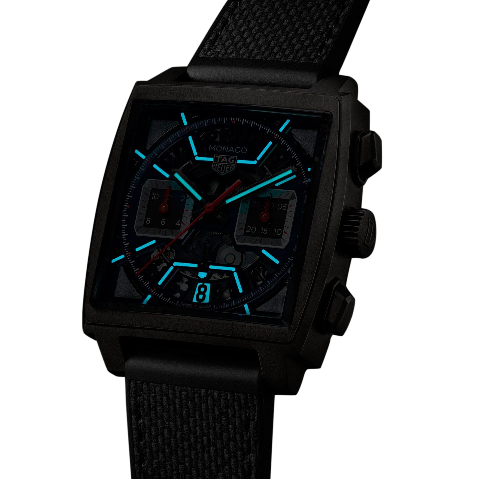 A TAG Heuer Monaco Chronograph wristwatch with a black square case, luminous blue hands and markers, red accents, and a black textured strap with calibre Heuer 02, shown against a white background.