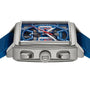 A TAG Heuer Monaco Chronograph wristwatch, featuring a square case, blue skeletonised dial, calibre Heuer 02 movement, red hands, two pushers, and a blue strap, is shown from the side.