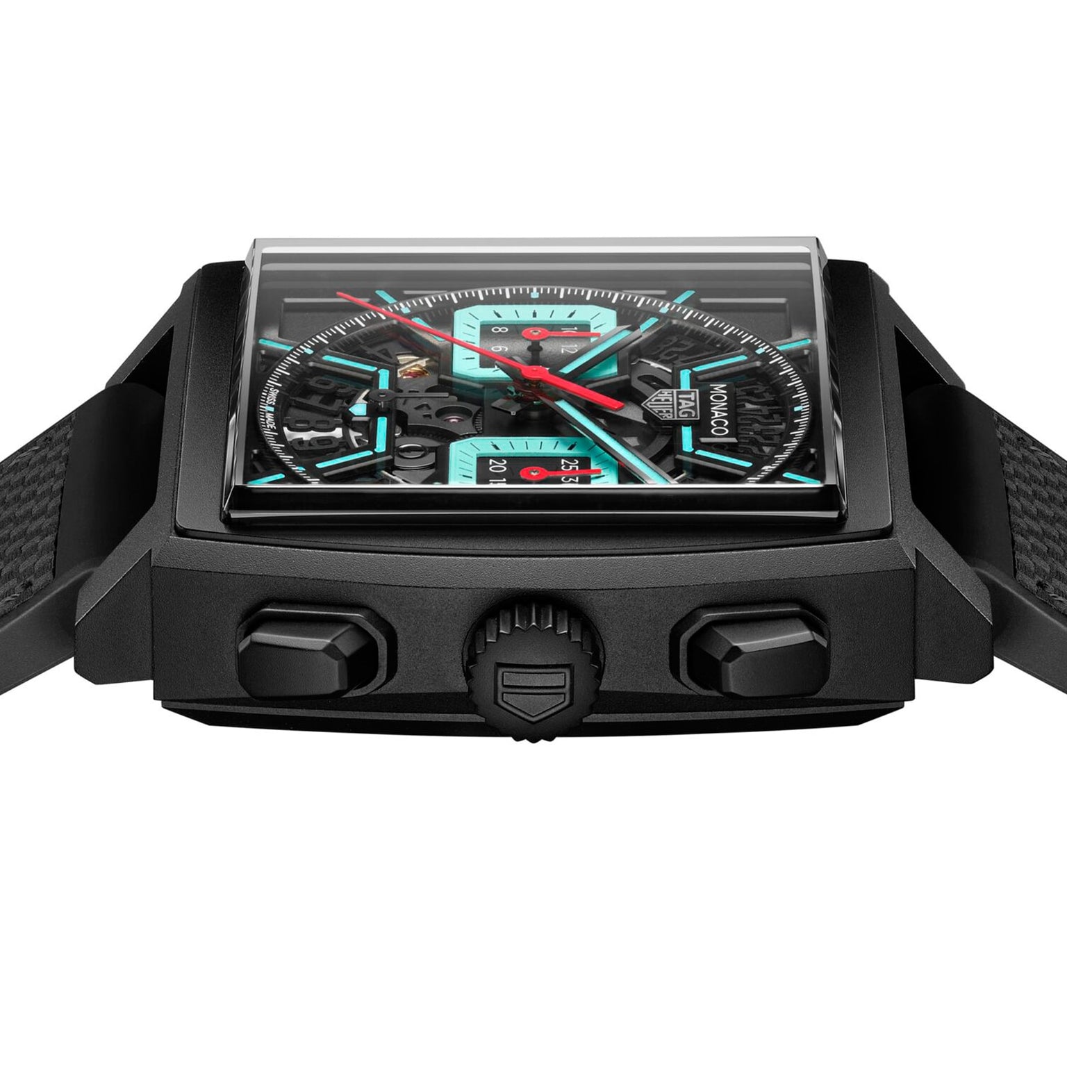 Close-up of a black square TAG Heuer Monaco Chronograph wristwatch featuring visible mechanical details, calibre Heuer 02 movement, red and turquoise accents, side buttons, and a textured strap.