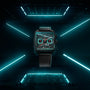 A TAG Heuer Monaco Chronograph with a square face and black strap is showcased in a futuristic dark setting under blue neon lights.