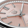 Close-up of the TAG Heuer Carrera Date watch face featuring a rose gold background, silver hour markers, crystal accents, and visible hour, minute, and second hands powered by an automatic movement.