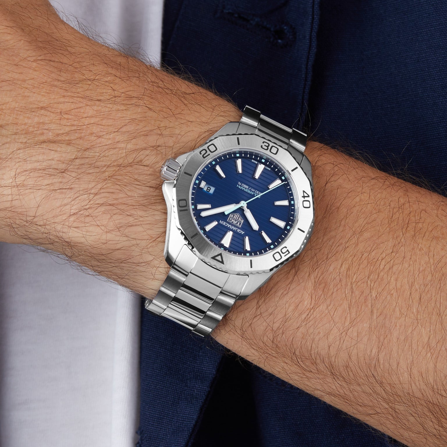 Someone wearing a TAG Heuer Aquaracer 200 Professional Solargraph wristwatch with a blue dial and silver bezel, showing the time as 10:10.