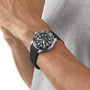 A person wearing a TAG Heuer Aquaracer Professional 300 Date with a rubber strap on their wrist, dressed in a grey shirt.