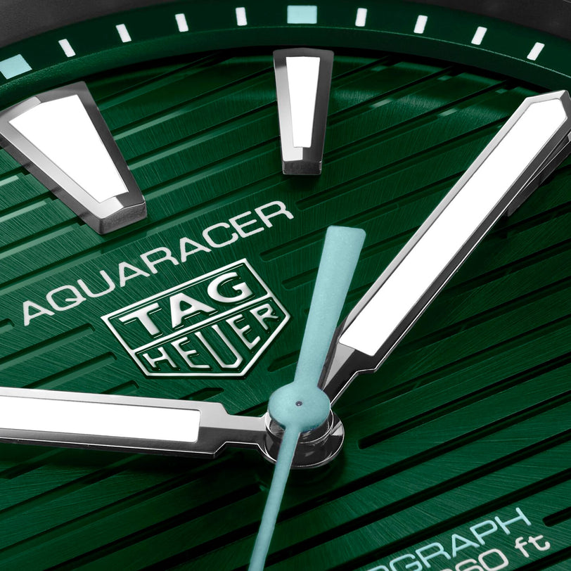 Close-up of a TAG Heuer Aquaracer Professional 200 Solargraph watch face with green textured dial, large white hour markers, silver hands, and a bold unidirectional bezel—highlighting TAG Heuer’s signature design.