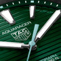 Close-up of a TAG Heuer Aquaracer Professional 200 Solargraph watch face with green textured dial, large white hour markers, silver hands, and a bold unidirectional bezel—highlighting TAG Heuer’s signature design.