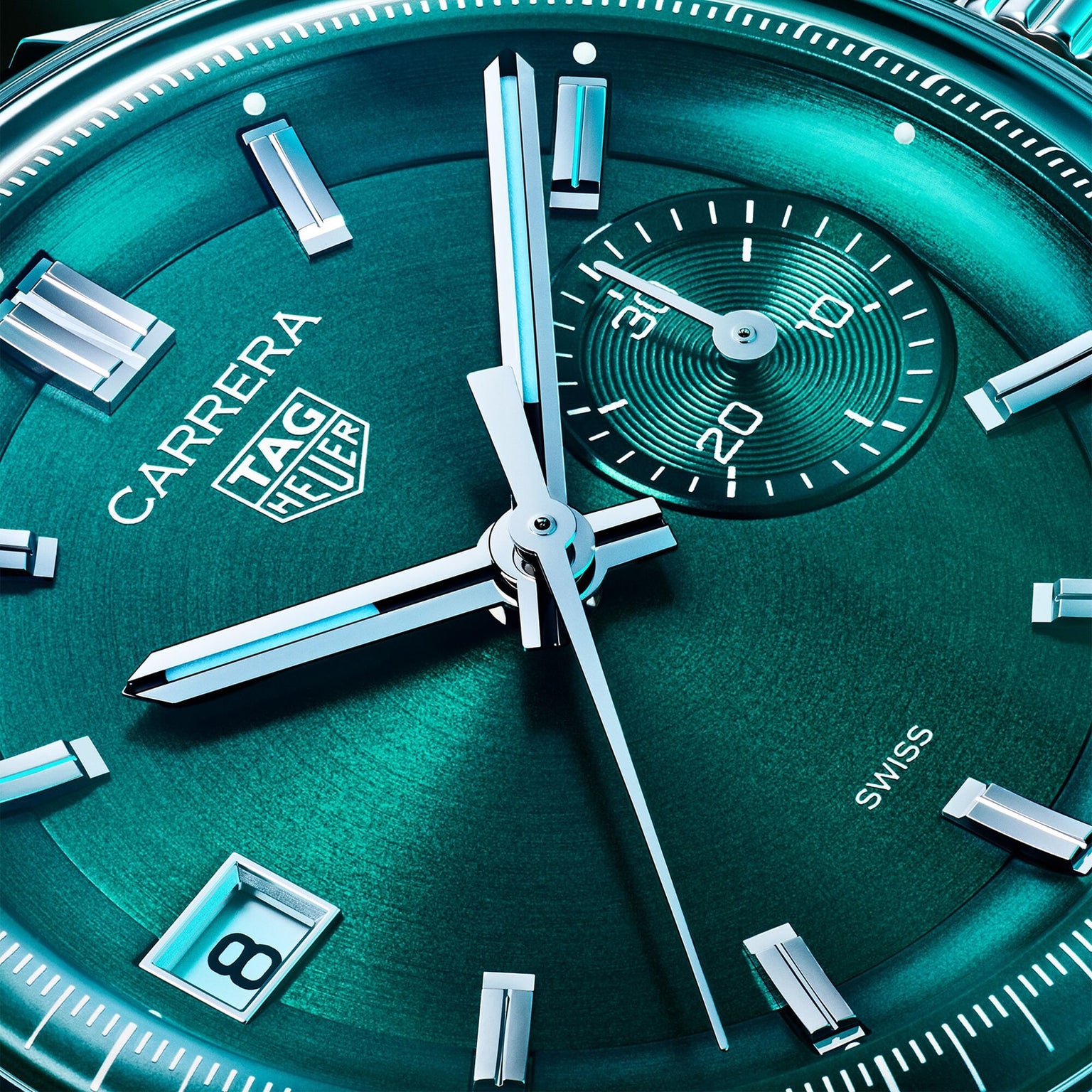 Close-up of a TAG Heuer Carrera Chronograph watch face with teal background, silver hour markers, date at 6 o’clock, and small seconds at 3 o’clock—powered by the precise TH20-07 automatic movement.