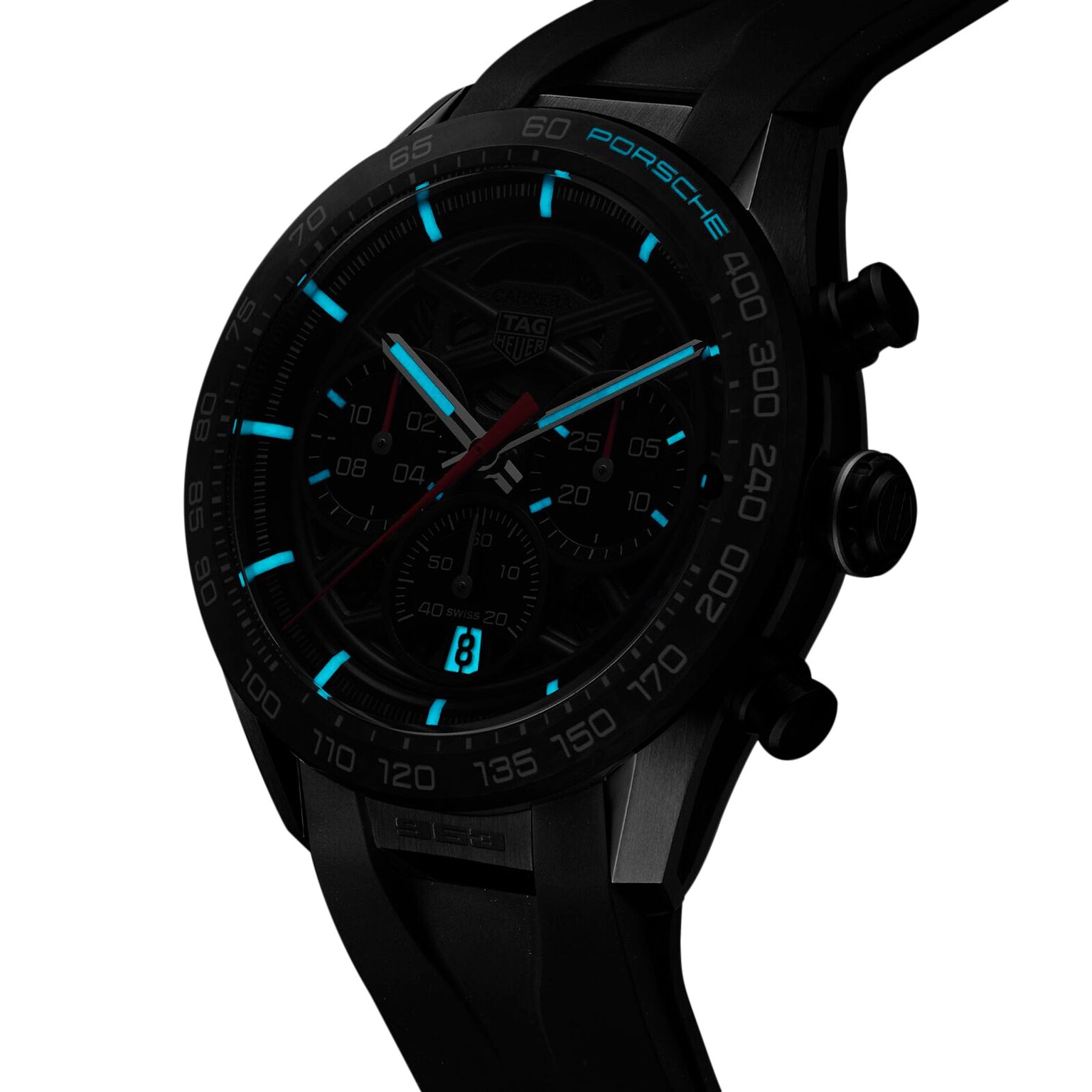 The TAG Heuer Limited Edition Carrera Chronograph x Porsche 963 features luminescent blue hour markers, a skeleton dial, black strap, and digital date display, shown on a white background.