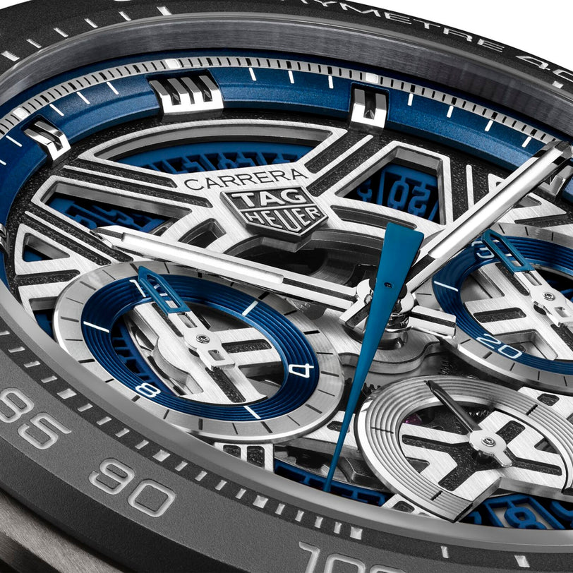 Close-up of a TAG Heuer Carrera Chronograph Extreme Sport watch face, showcasing blue, silver, and black details, visible gears driven by the TH20-00 movement, striking hands, and intricate subdials.