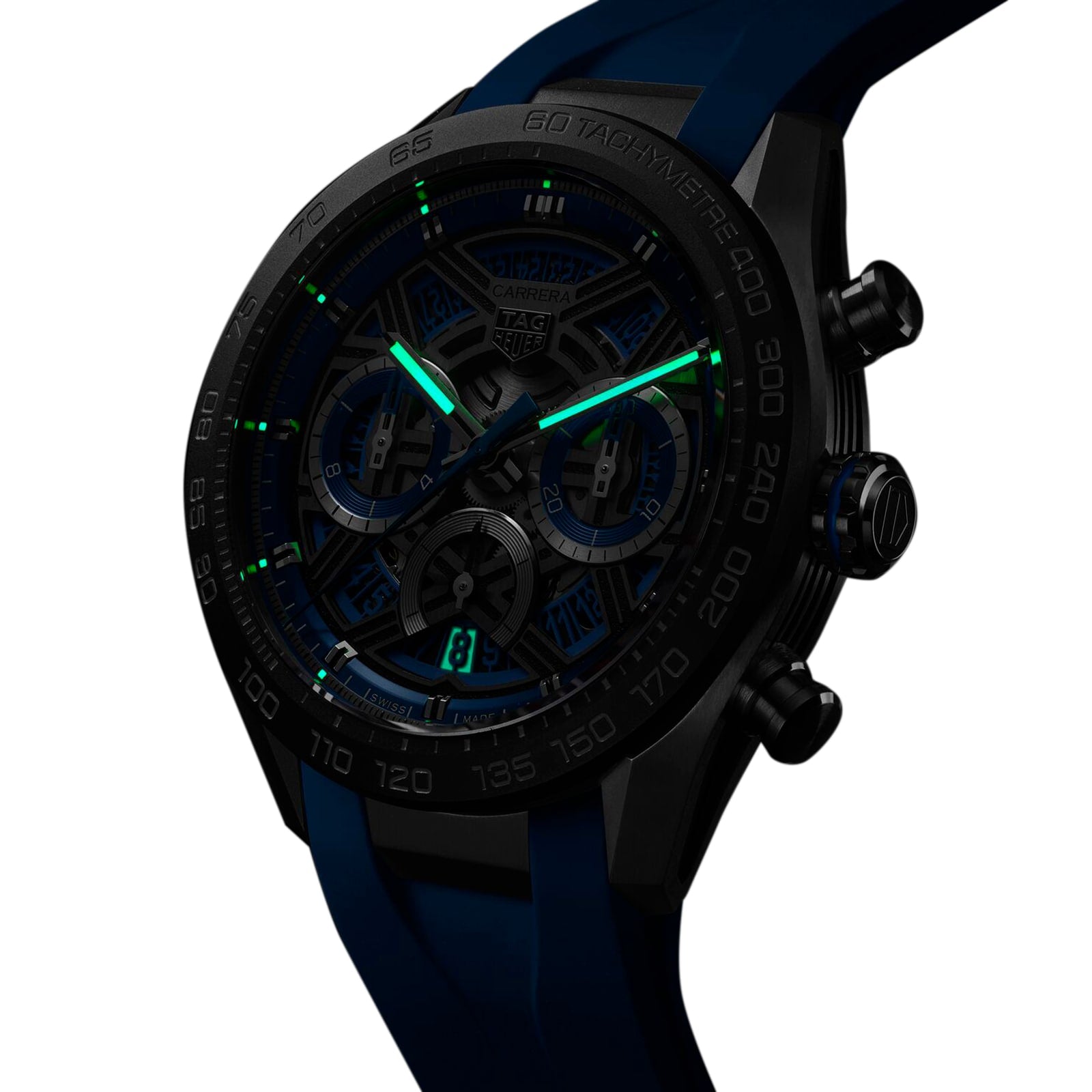 The TAG Heuer Carrera Chronograph Extreme Sport wristwatch, in black and blue, features luminous green hands and hour markers, shown glowing in low light.