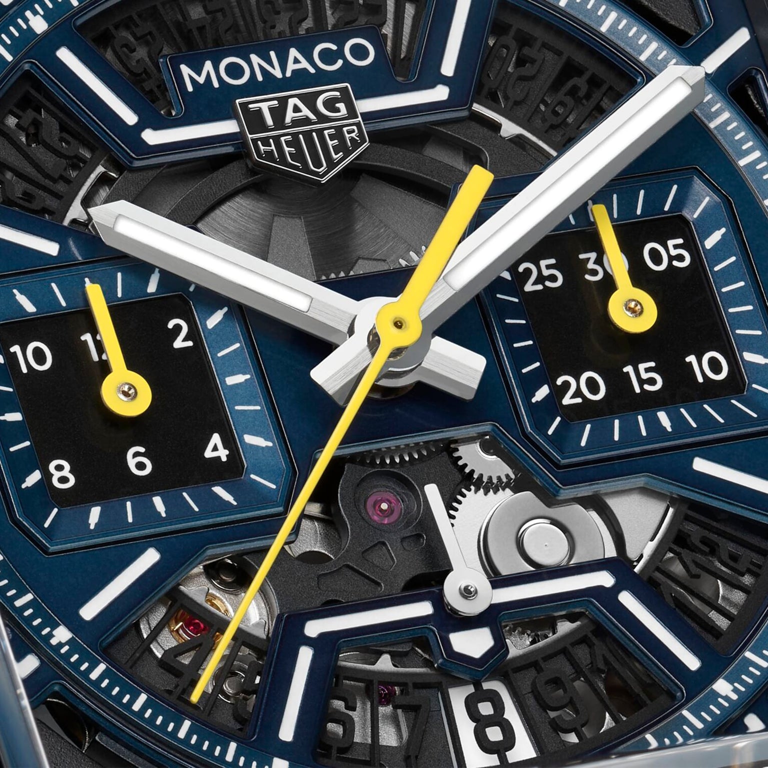 Close-up of a TAG Heuer Monaco Chronograph watch face, featuring hands, dials, gears, and the iconic TAG Heuer logo.