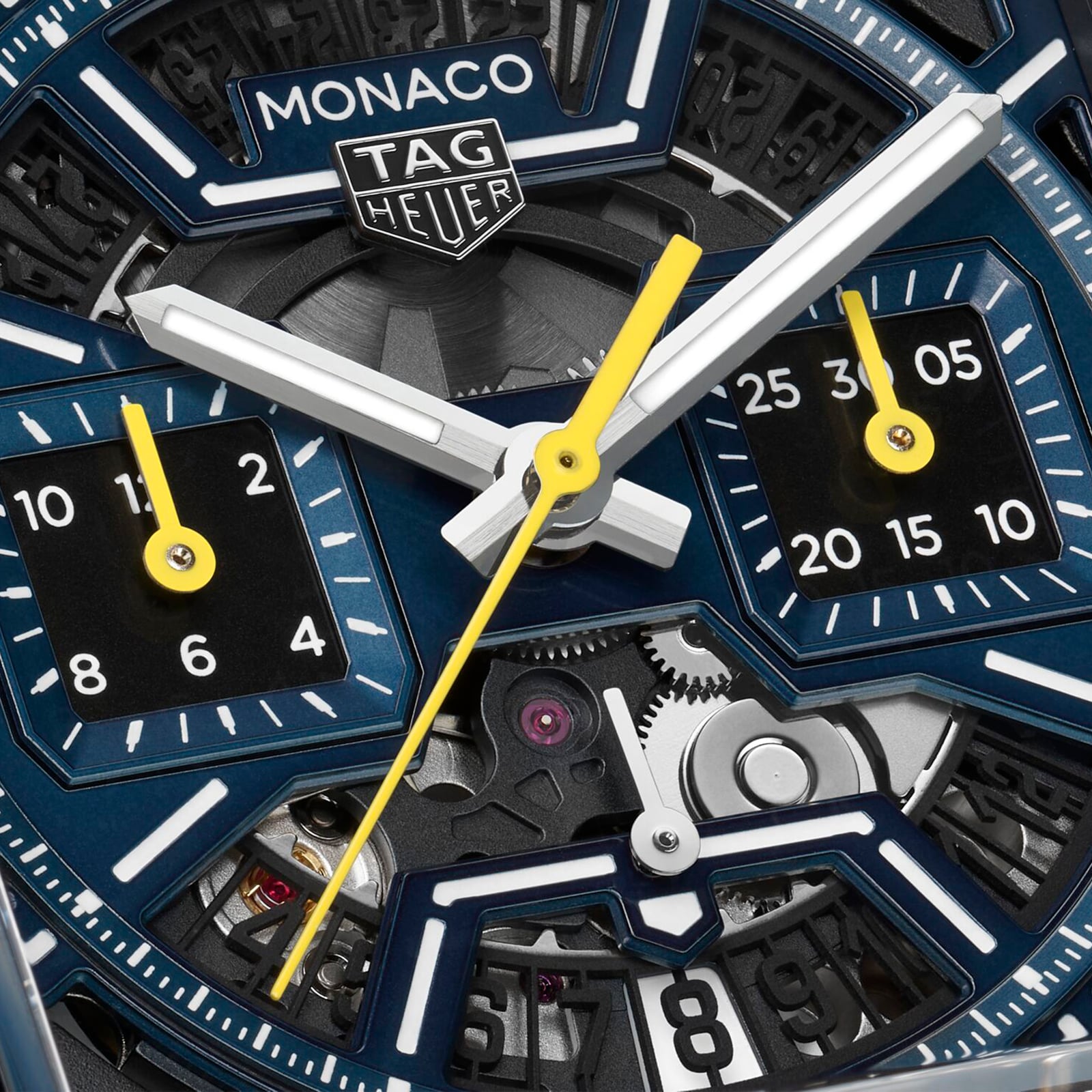 Close-up of a TAG Heuer Monaco Chronograph watch face, featuring hands, dials, gears, and the iconic TAG Heuer logo.