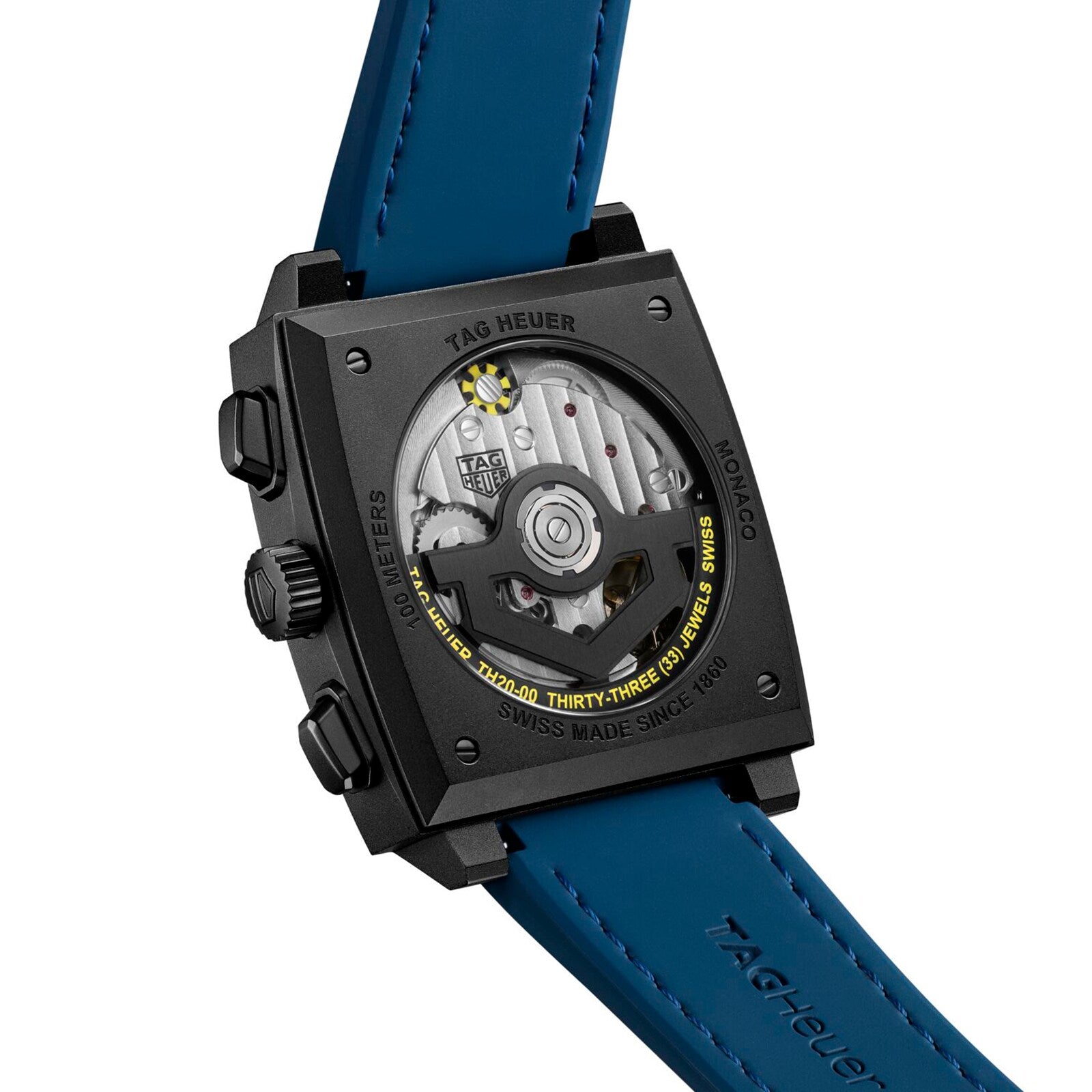 Back view of the TAG Heuer Monaco Chronograph, showcasing its square titanium case, labeled details, blue strap, and visible automatic movement with rotor through a transparent case back.