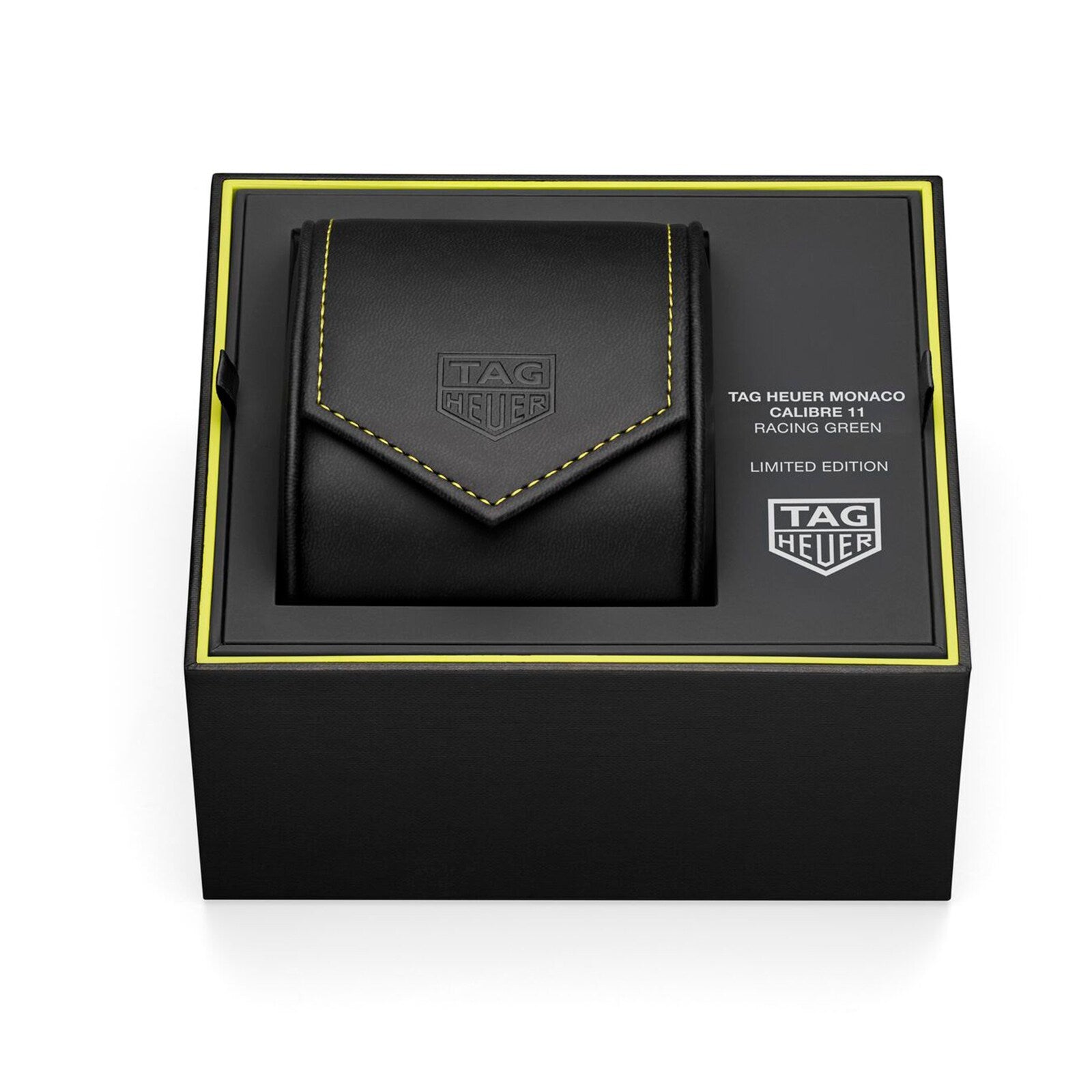 A black TAG Heuer Monaco Chronograph Racing Green watch case with yellow stitching rests inside a black box labeled TAG Heuer Monaco Chronograph Racing Green.