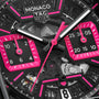 Close-up of the TAG Heuer Monaco Chronograph watch face, featuring black and hot pink details with visible gears and dials.