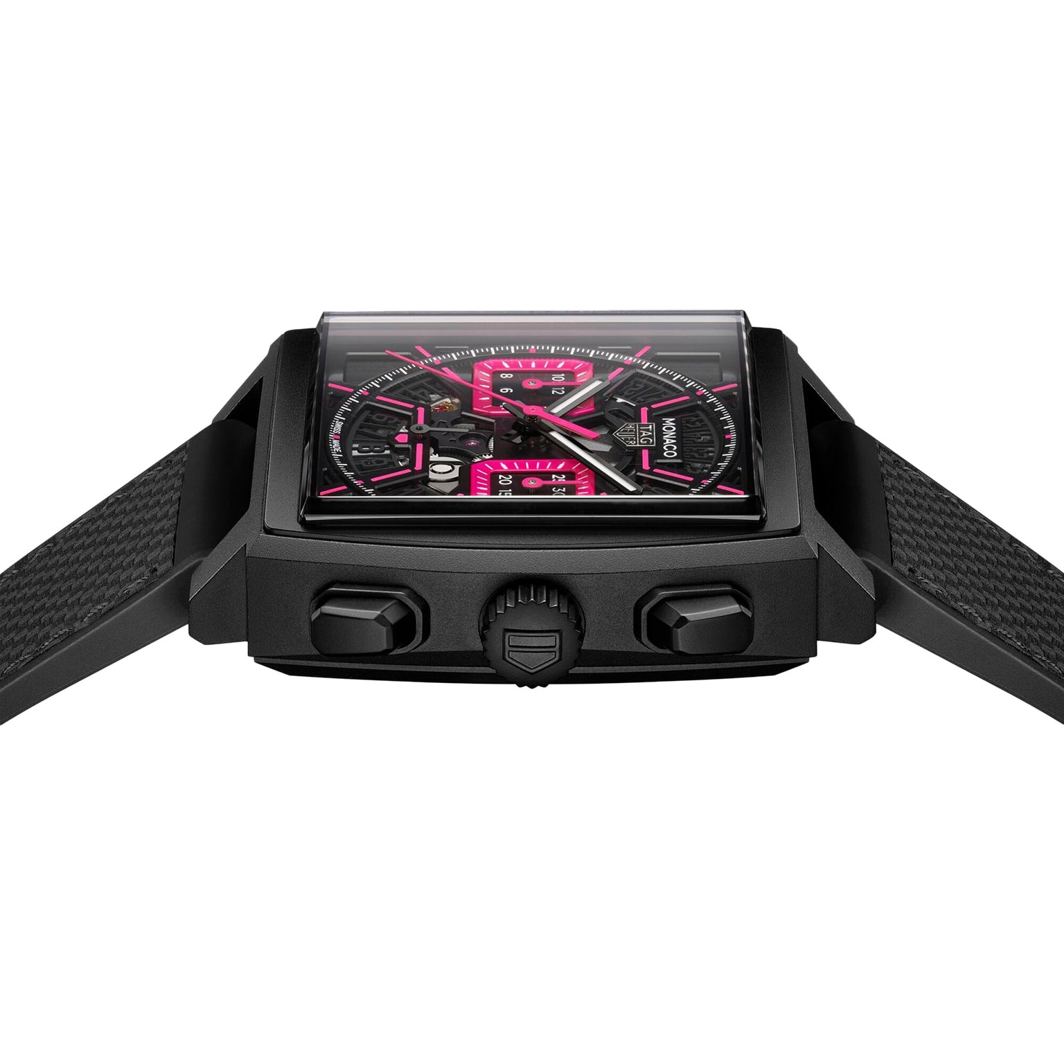 The TAG Heuer Monaco Chronograph features a square titanium case, black dial with pink accents, textured strap, and three side buttons, photographed on a white background.