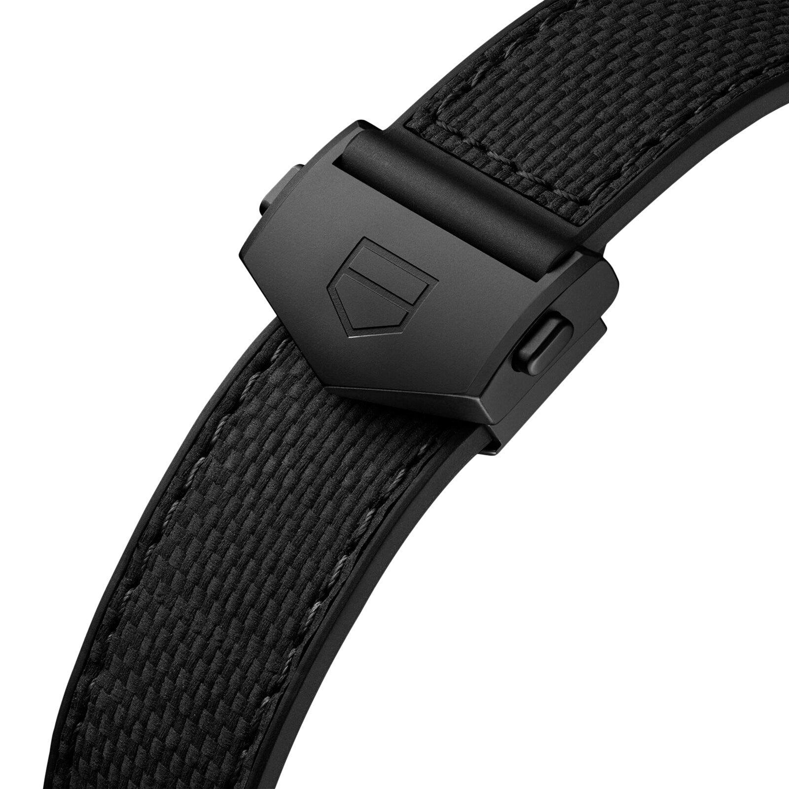 Close-up of a black textured watch strap with matte black deployment clasp and embossed shield logo, designed to complement the square titanium case of the TAG Heuer Monaco Chronograph.