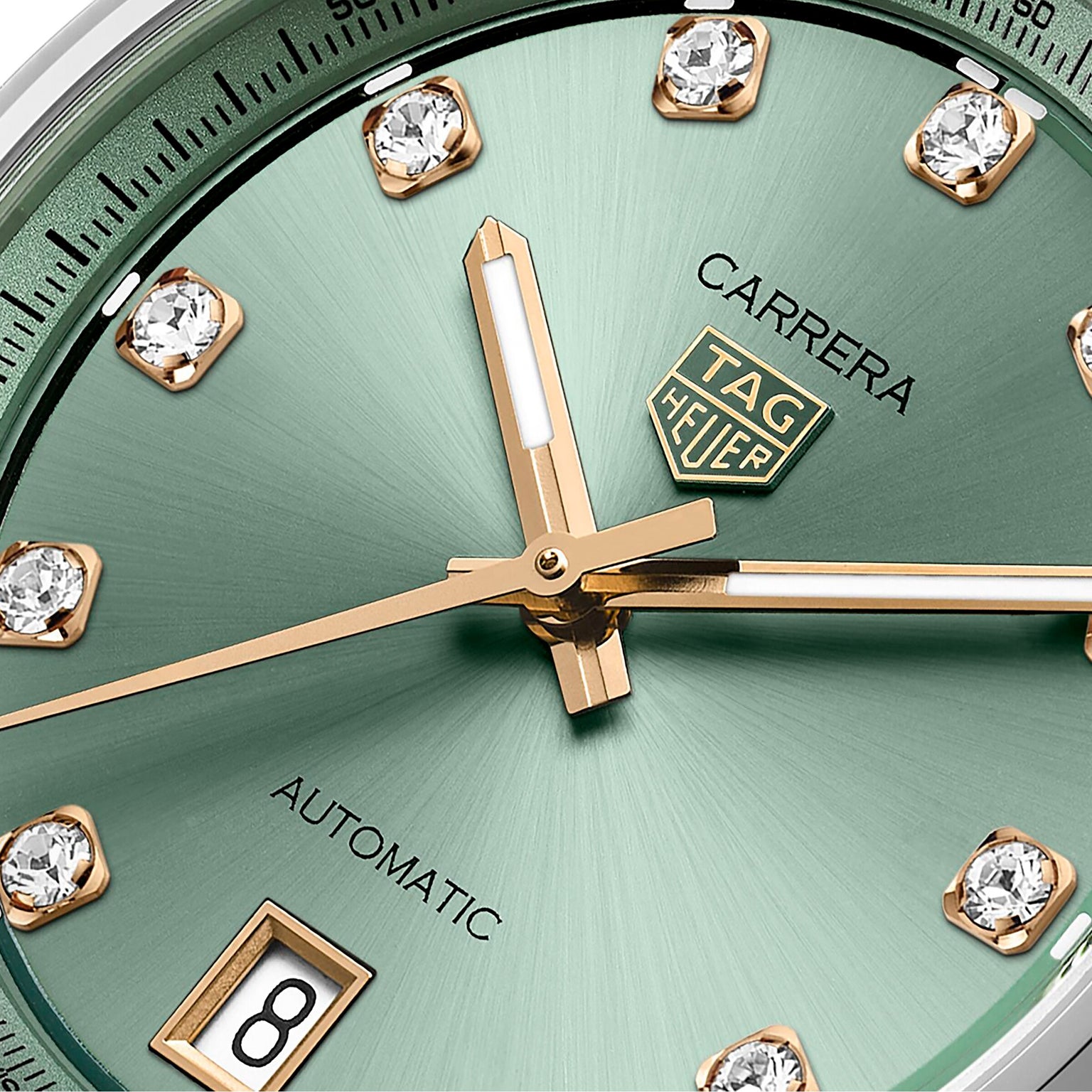 Close-up of the TAG Heuer Carrera Date, showcasing its green sunray-brushed dial with gold hands, diamond hour markers, and a date window at 6 o’clock.