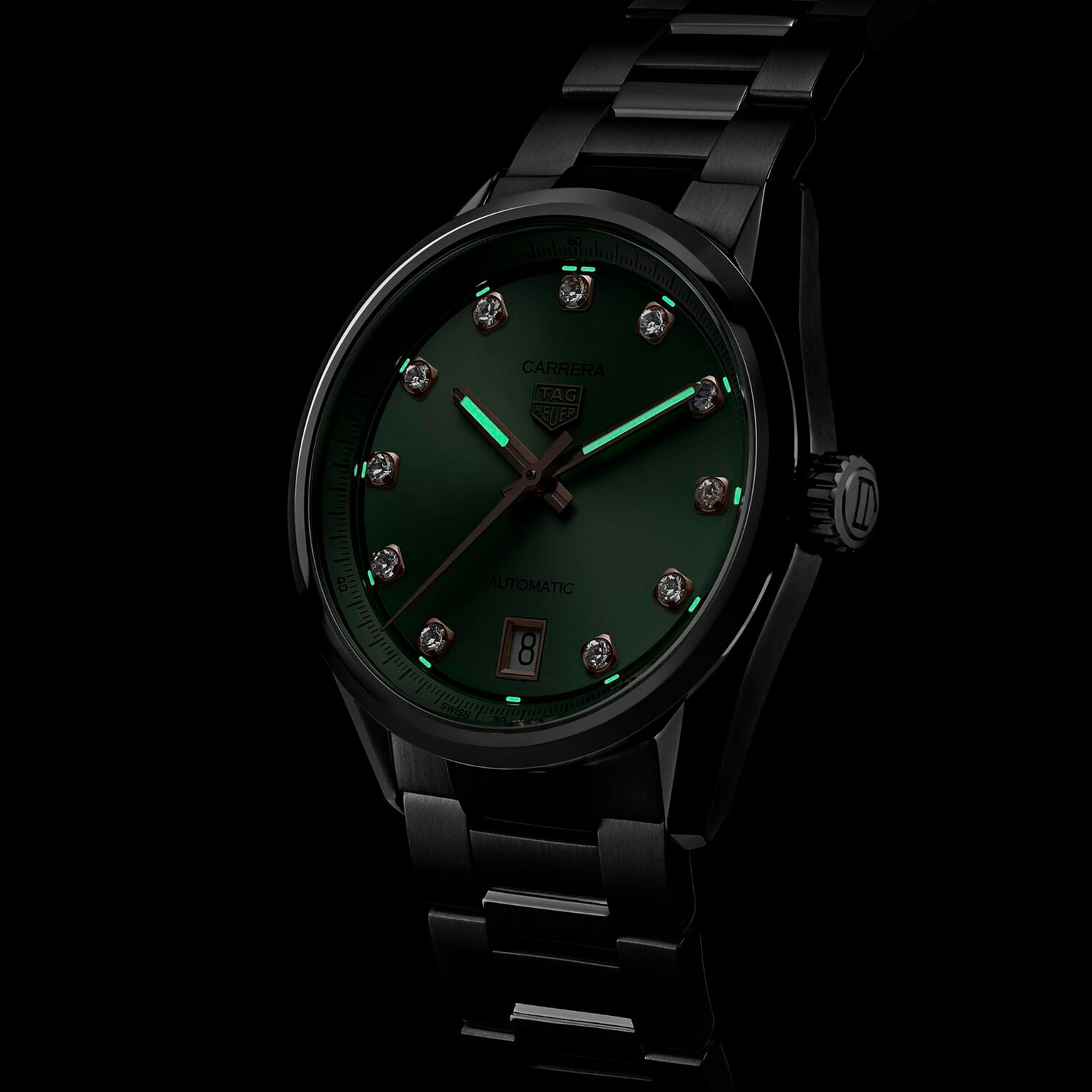 The TAG Heuer Carrera Date is a black metal wristwatch with a green sunray-brushed dial, diamond hour markers, date display at 6 o’clock, and Carrera branding.