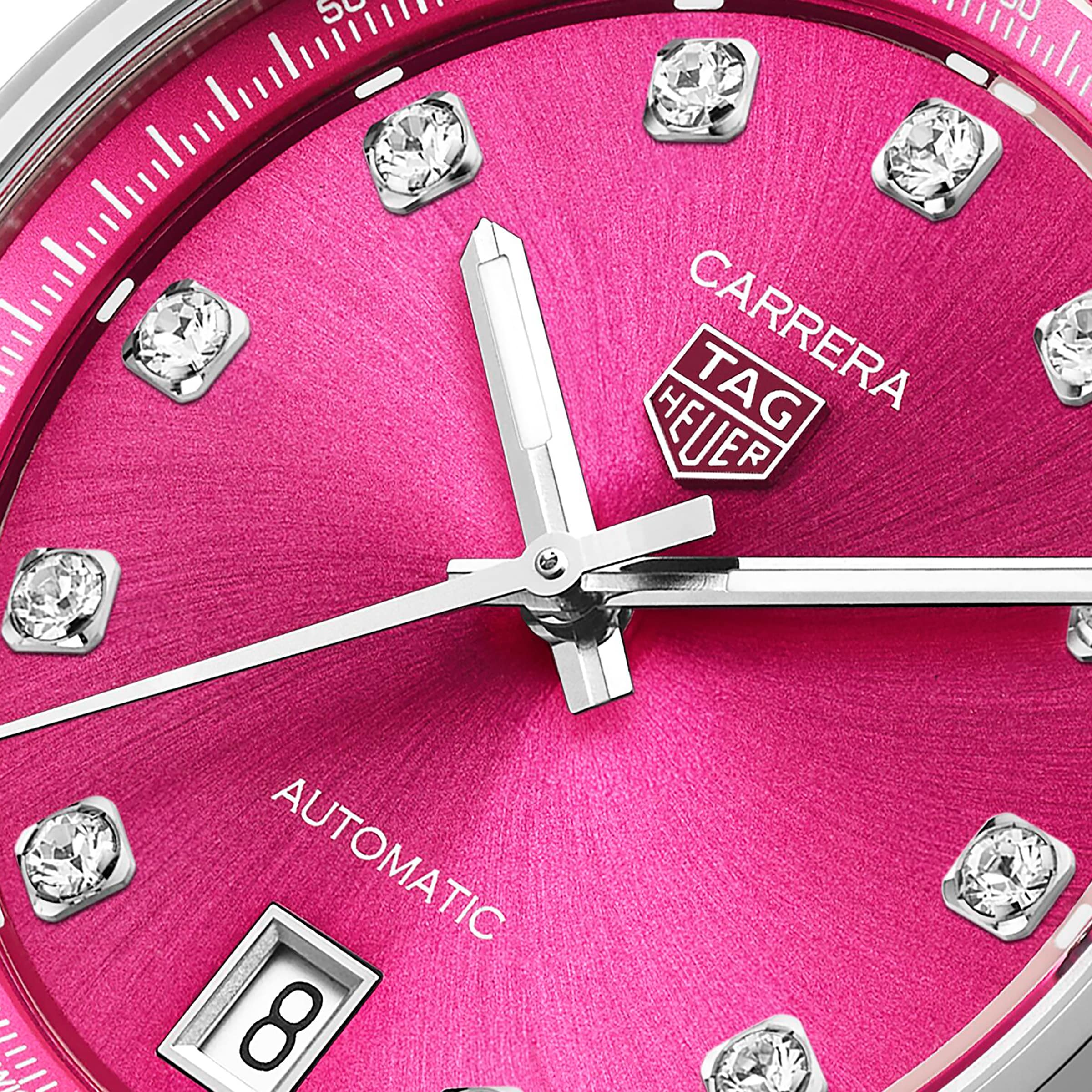 Close-up of the TAG Heuer Carrera Date watch face with a pink snail-brushed dial, VS diamond hour markers, date window, and silver hands.