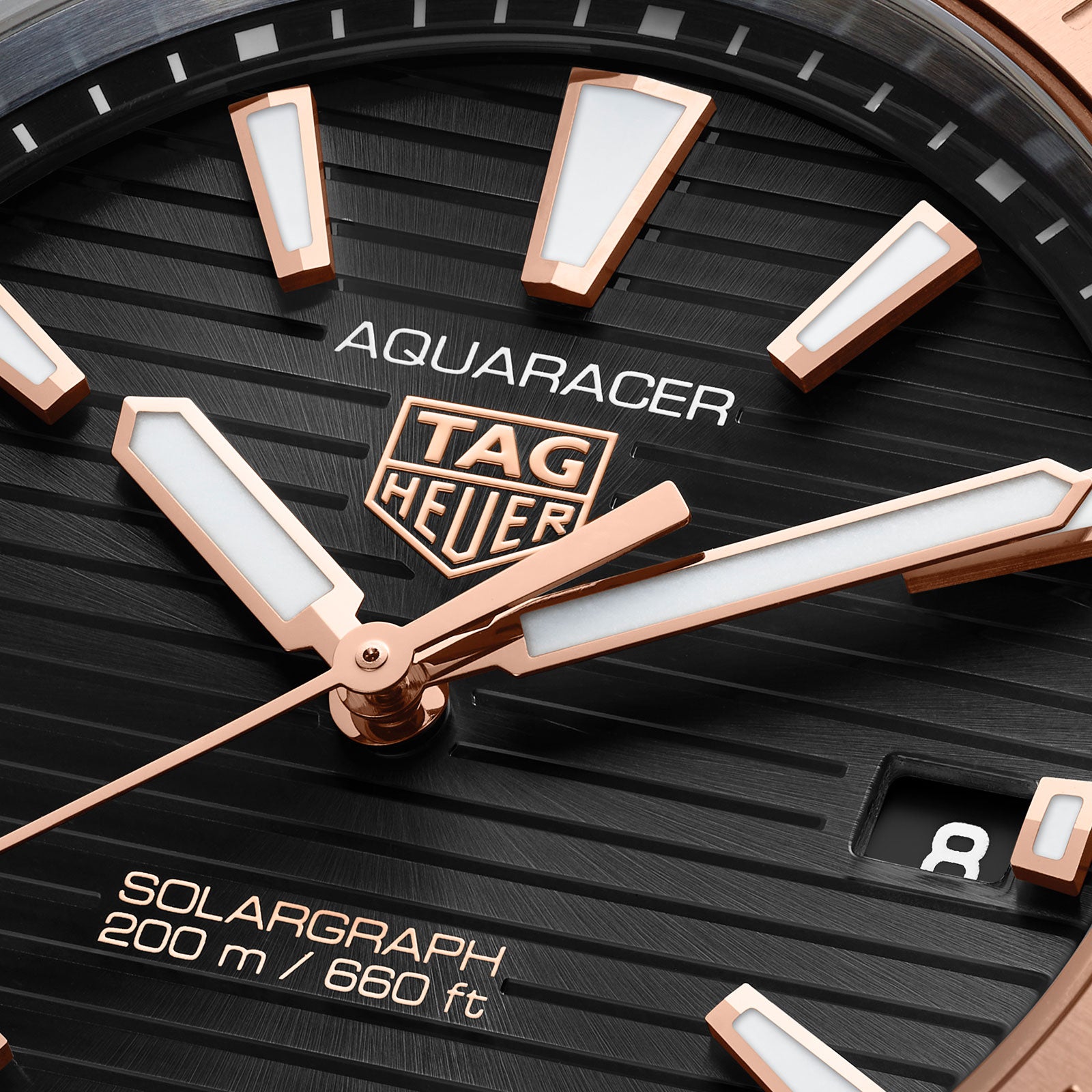 Close-up of the TAG Heuer Aquaracer Professional 200 Solargraph watch face, featuring a two-tone design, gold and white hands, logo, date window, and 200m/660ft depth rating.