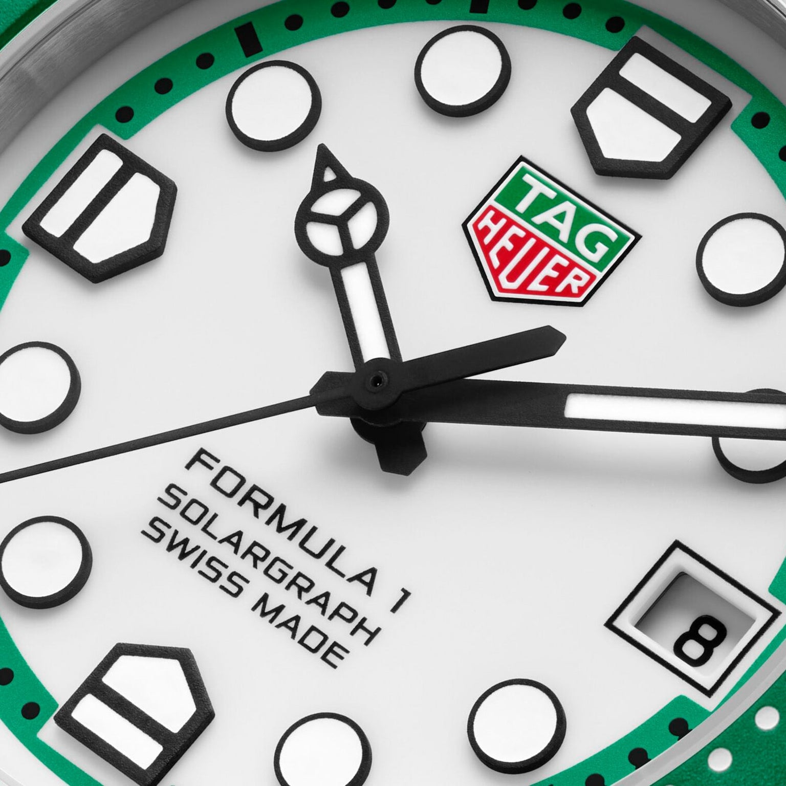 Close-up of a TAG Heuer Formula 1 Solargraph watch face with green accents and a date display at 3 o’clock.