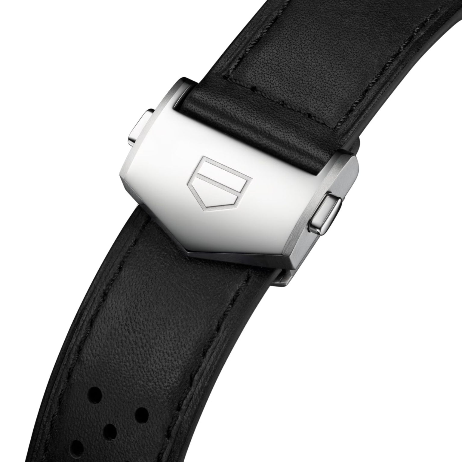 Close-up of a TAG Heuer Carrera Chronograph buckle with a brushed metal clasp engraved with the brand’s shield logo, set on a black leather strap that perfectly complements its smokey purple sunray brushed dial.