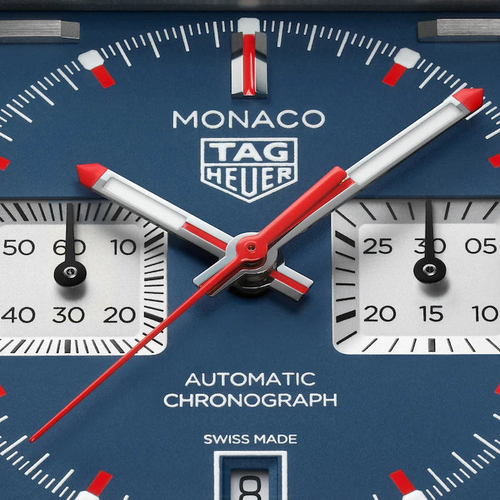 Monaco TAG Heuer chronograph watch face with blue dial, red and white hands, and subsidiary dials.