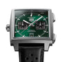 Square stainless steel chronograph watch with green dial, black subdials, white hands, and black perforated rubber strap.