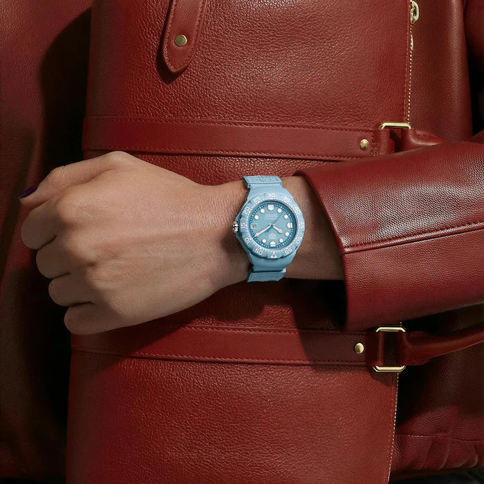 Hand wearing a blue watch on a red leather jacket
