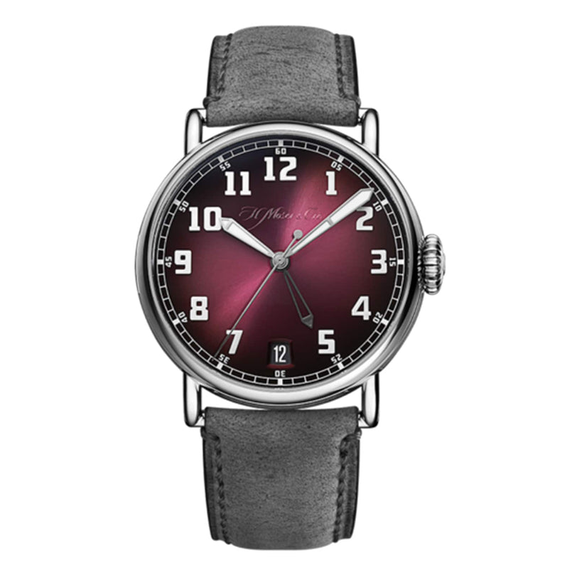 The H. Moser & Cie Heritage Dual Time features a burgundy fumé dial, silver numerals, date at 6 o’clock, and a gray leather strap—an ideal wristwatch for adventurous spirits.