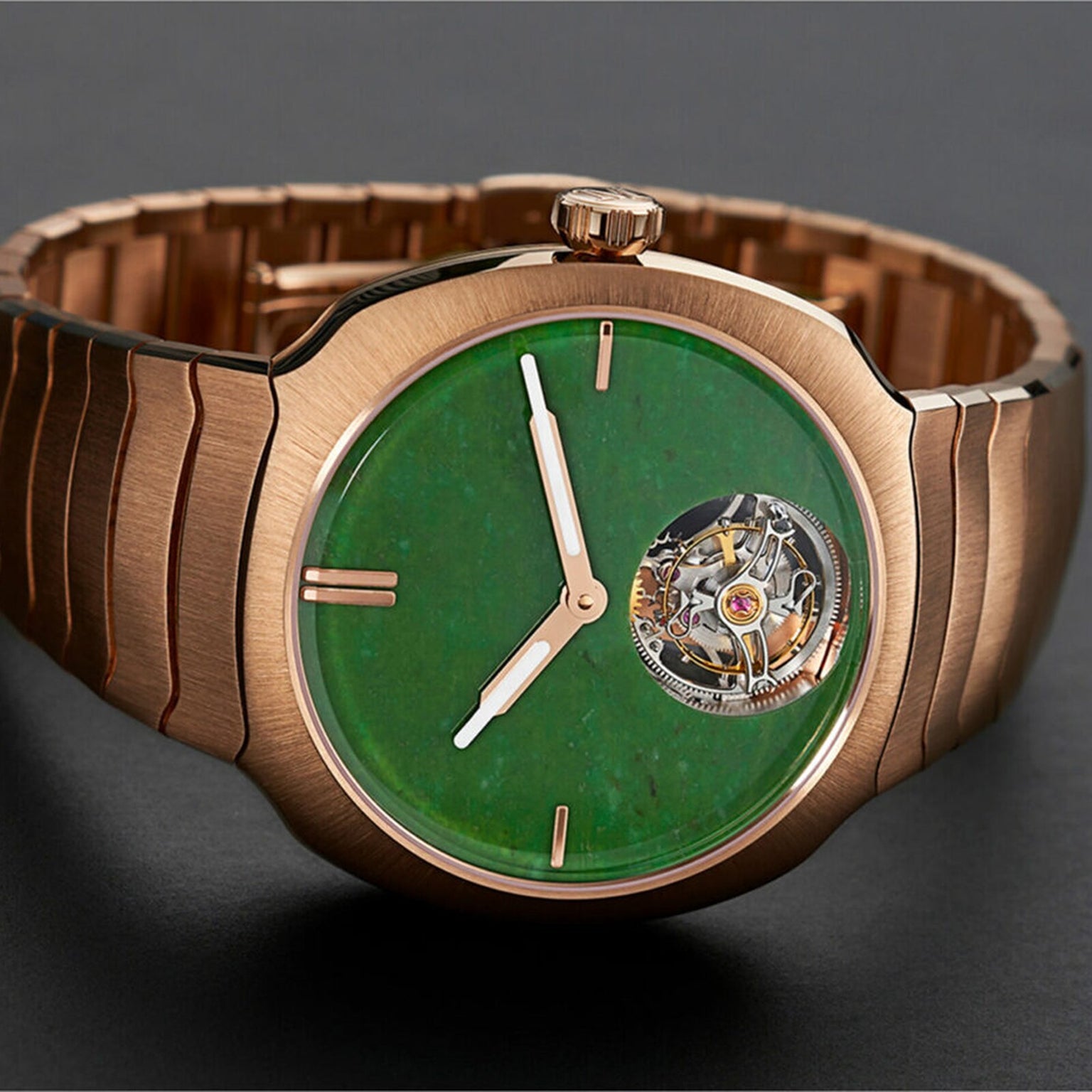 The H. Moser & Cie Streamliner Tourbillon is a red gold wristwatch with a green Wyoming jade dial, minimal golden hour markers, and an exposed double hairspring flying tourbillon at 1 oclock.