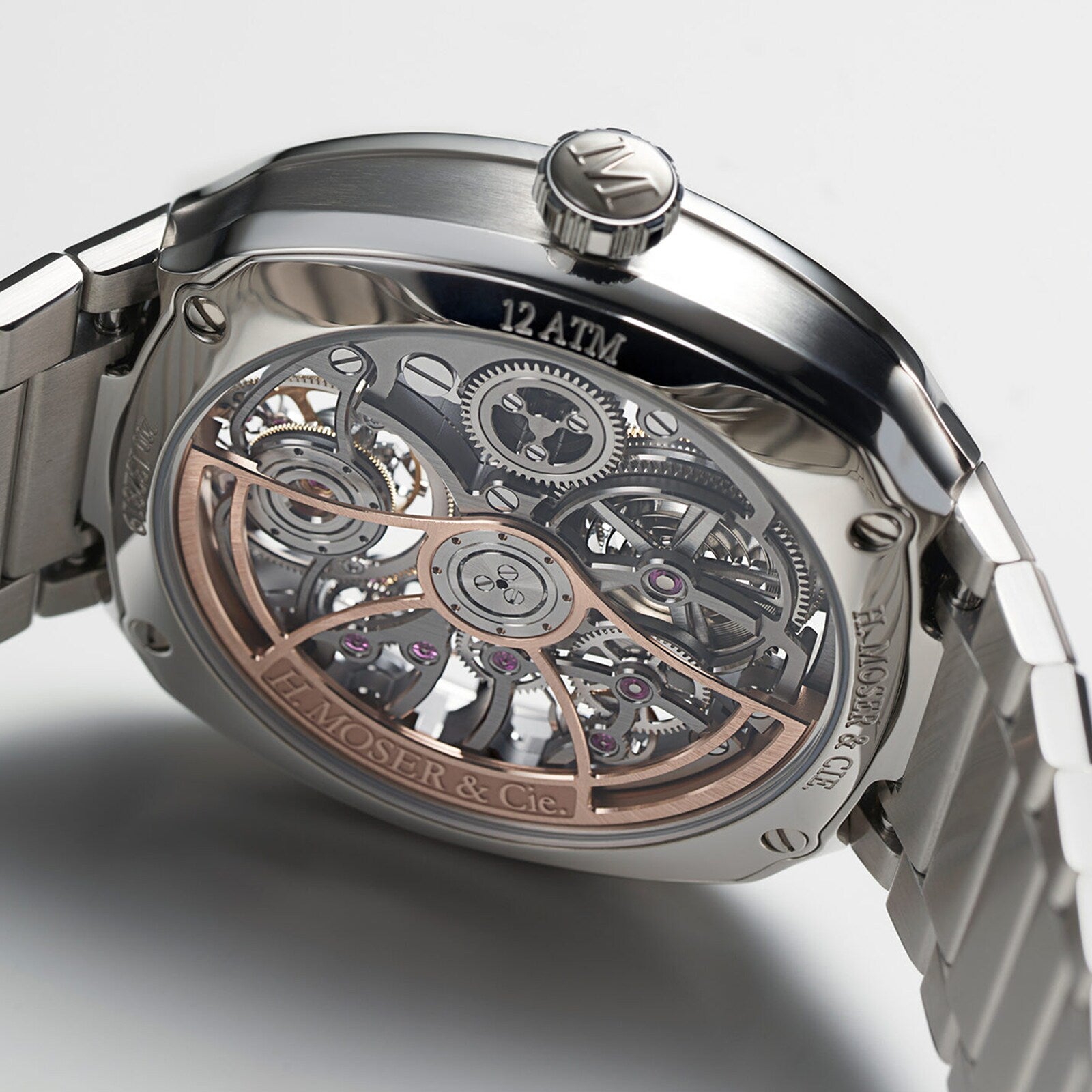 Close-up of the back of the H. Moser & Cie Streamliner Tourbillon Skeleton, showcasing its exposed tourbillon movement and intricate gears, with H. Moser & Cie and 12 ATM labeled on the metal case.