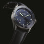 The Blancpain Fifty Fathoms Bathyscaphe features a blue dial, luminous markers, automatic movement, and a black fabric strap, shown on a black background.