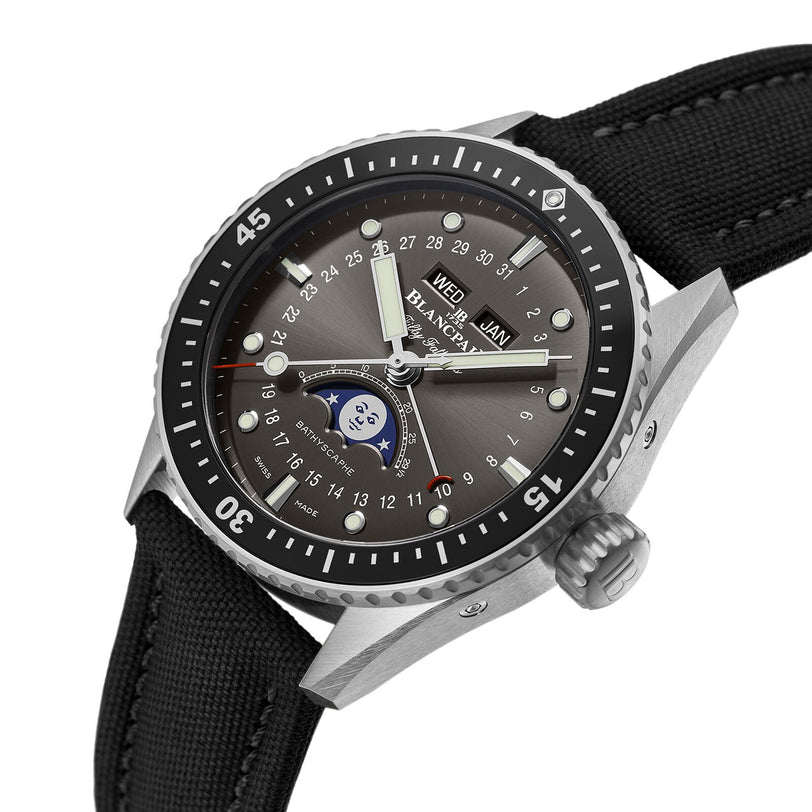 A luxury timepiece, the Blancpain Fifty Fathoms Bathyscaphe Quantième Complet Phases de Lune features a stainless steel case, black bezel and fabric strap, day-date moonphase subdial, and luminous markers—exuding signature Blancpain elegance.