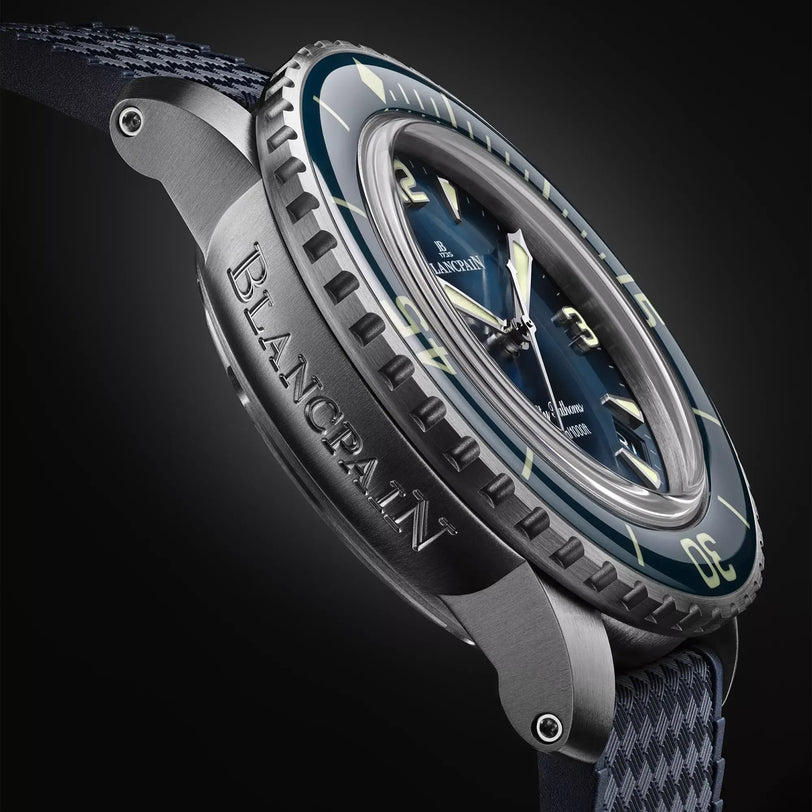 Close-up view of the Blancpain Fifty Fathoms Automatique wristwatch featuring a blue dial, bold markers, and a textured dark strap.