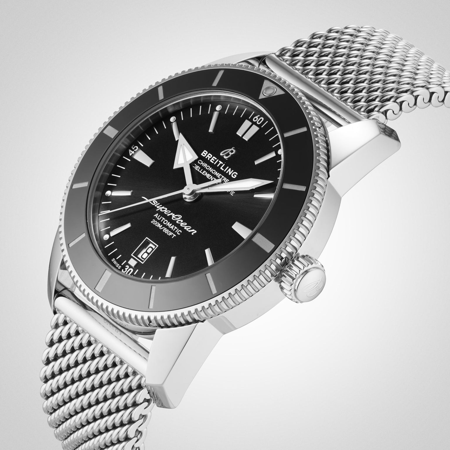 A Breitling Superocean Heritage B20 Automatic 46 watch with a black dial, date display, mesh bracelet, and 46mm stainless steel case is shown at an angle on a plain background.