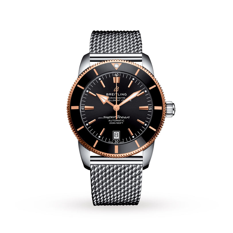 The Breitling Superocean Heritage B20 Automatic 42 features a black dial, rose gold bezel, date display, and a silver mesh strap, all powered by the precise Breitling B20 movement on a white background.