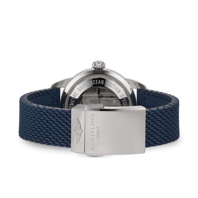 The image shows the back of a Breitling Superocean Heritage B20 Automatic 44, featuring a blue textured strap and a stainless steel clasp engraved with the Breitling logo and 1884.