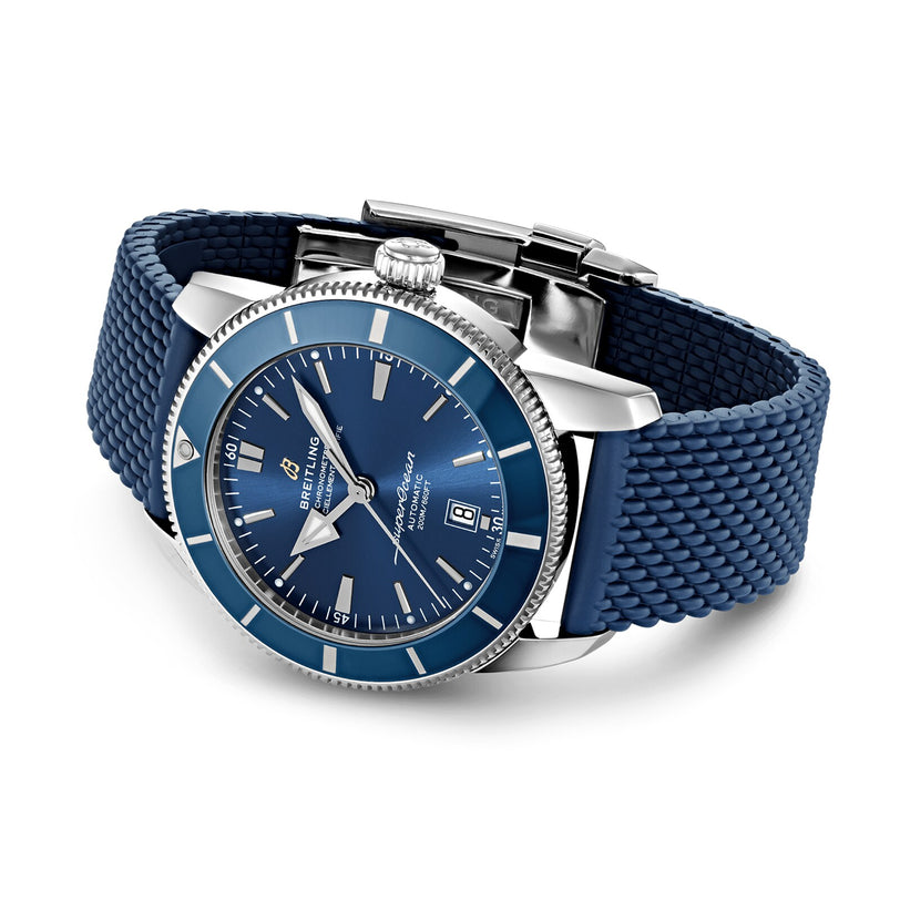 A Breitling Superocean Heritage B20 Automatic 46 wristwatch in stainless steel features a blue dial, date display, luminescent hands, and a mesh-patterned blue rubber strap, shown against a white background.