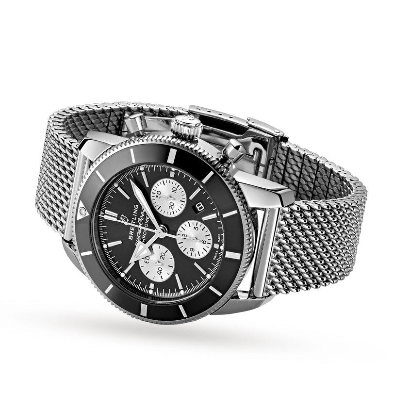 A Breitling Superocean Heritage B01 Chronograph 44 wristwatch in stainless steel with a black dial, three subdials, date window, and silver mesh strap, shown angled on a white background.