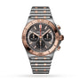 The Breitling Chronomat B01 42 is a striking two-tone stainless steel and rose gold chronograph watch featuring a black dial with three subdials, tachymeter markings, and a metal link bracelet.