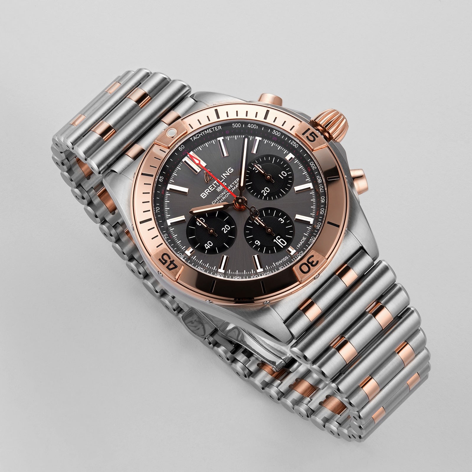 A Breitling Chronomat B01 42 mechanical watch in stainless steel and rose gold featuring a black dial with three subdials, shown on a light gray background.